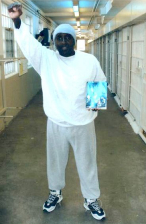 Kenny Zulu Whitmore holding the autobiography of Angola Three member Robert Hillary King